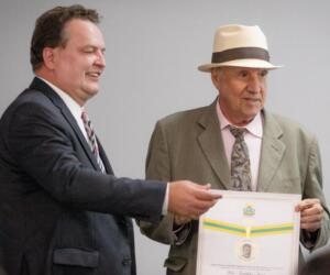 Presidente Max homenageia Hélio Faust com a comenda Dante de Oliveira